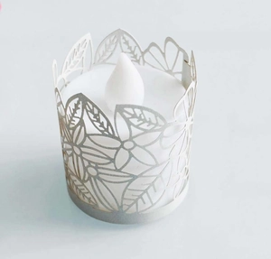 Close-up of laser-cut floral paper wrapper with white LED electronic tea light candle