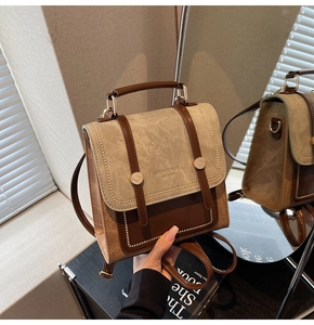 Close-up of a vintage brown and beige backpack featuring elegant textured leather stitching