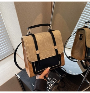Detail of vintage patchwork backpack showing gold rivet trim and premium suede texture