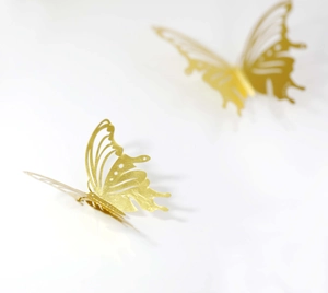 Detailed macro view of 3D gold hollow butterfly wall sticker with laser-cut texture