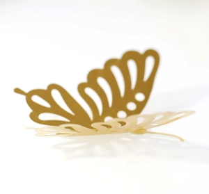 Detail of 3D metallic gold butterfly wall sticker with intricate hollow cutout design