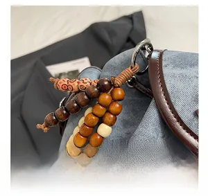 Vue macro de bijou de sac en perles de bois rétro avec motifs rouges et mousqueton