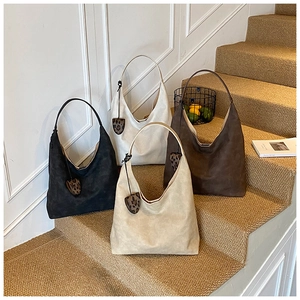 Detailed view of large vintage tote bags in suede finish with leopard heart charms