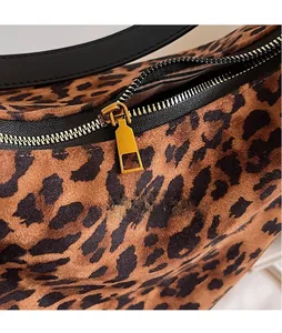 Detail of leopard print bucket bag featuring gold metal zipper and striped fabric lining