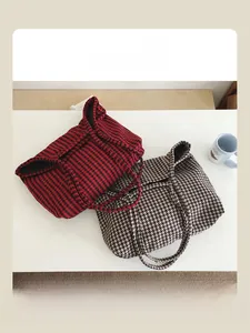Detail of red and beige houndstooth tote bags in thick woven fabric for commuting