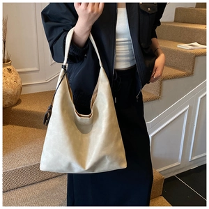 Chic off-white large tote bag worn on shoulder in a stylish minimalist interior setting