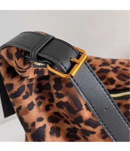 Close-up of leopard print bucket bag with black leather strap and gold metal buckle