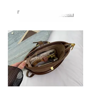 Detail view of brown bucket bag showing large capacity interior with neat compartments
