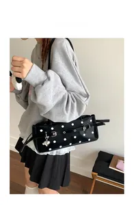 Detailed close-up of a French retro polka dot baguette bag with a silver heart pendant
