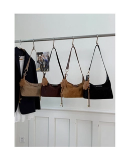 Detail showing vintage style suede shoulder bags in four colors with bear charms