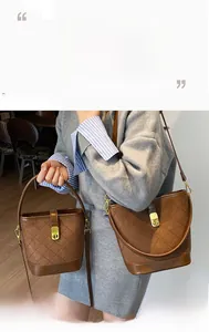 Detail of dark brown quilted suede bucket bags with gold buckles and adjustable straps