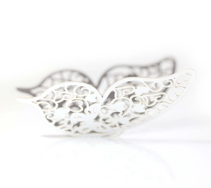 Macro detail of 3D silver butterfly sticker with intricate laser-cut heart patterns