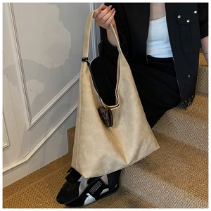 Retro beige tote bag with leopard heart charm shown in a lifestyle commuter setting