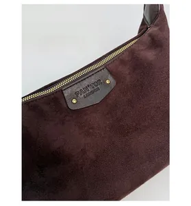 Close-up of the vintage dark coffee PU suede bag featuring a branded leather logo patch