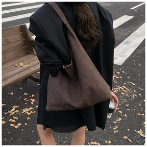 Close-up of deep brown suede tote bag featuring a seamless minimalist design for fall fashion