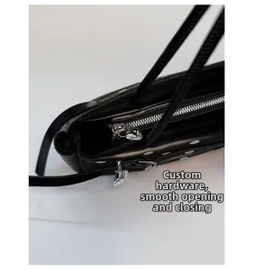 Detail of custom silver heart-shaped zipper pulls on a black polka dot leather bag