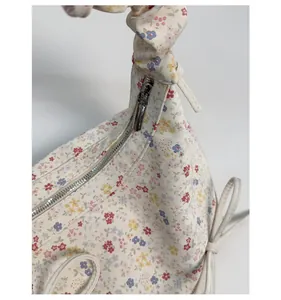 Détail de la fermeture éclair en argent et poignée nouée sur sac floral