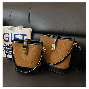 Detail of brown quilted bucket bag with golden twist lock and black leather trim