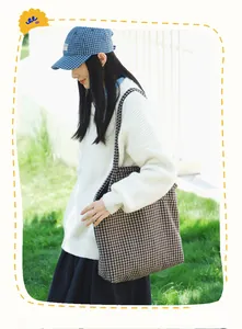 Detail of large houndstooth tote bag featuring classic brown and black textured fabric