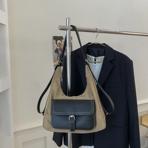 Detail of vintage crossbody bag with khaki suede body and black leather flap pocket