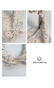 Détail du sac à fleurs montrant le ruban, le zip en métal et la poignée à volants