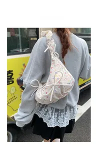 Détail d'un sac à bandoulière plissé à fleurs avec cordon de serrage et nœud doux