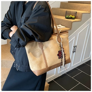 Borsa tote minimalista in tela beige e pelle marrone con ciondolo a forma di orsetto