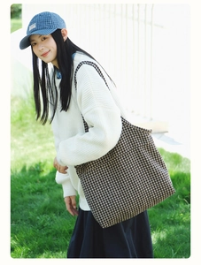 Chic houndstooth tote bag shown on model in a sunny outdoor lifestyle setting