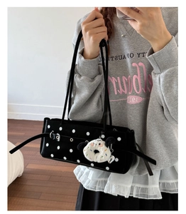 Detailed shot of retro polka dot handbag with silver buckle and plush dog charm