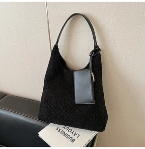 Detail of black fuzzy faux fur tote bag with matching leather strap and coin pouch