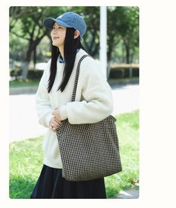Classic houndstooth tote bag shown over the shoulder with an autumn casual outfit
