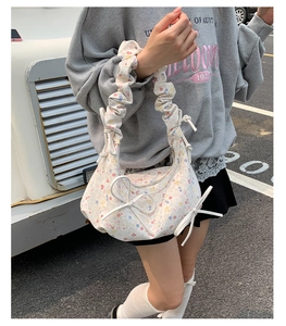 Détail du sac à fleurs blanc avec nœuds 3D et bandoulière froncée style nuage