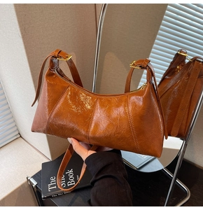 Détails du cuir ciré marron et de la boucle dorée du sac sous le bras élégant