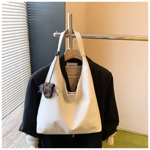 Detail view of cream white leather tote bag with leopard print mini pouch accessory