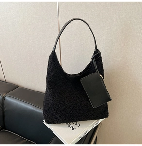 Close-up of black fuzzy tote bag and detachable pouch on minimalist leather background