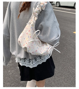 Détail du sac dumpling en toile florale avec bandoulière plissée et nœud décoratif