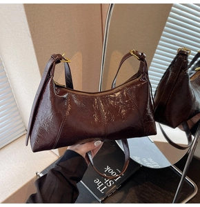 Détail du sac hobo en cuir ciré marron foncé avec ferrures dorées et bandoulière