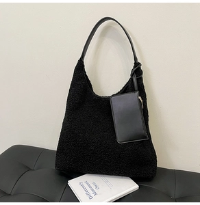 Detail view of black faux fur tote bag with leather strap and small zipper pouch