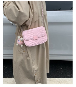 Rosa gesteppte Umhängetasche mit Goldkette und Plüschanhänger an einem Model