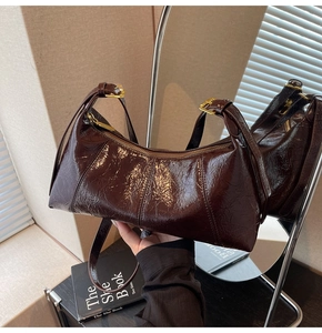 Détail du sac demi-lune marron foncé en cuir ciré avec fermeture éclair dorée élégante