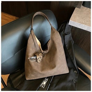 Detail of dark brown suede-textured hobo tote bag with stylish leopard pattern accessory