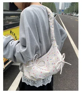 Détail du sac cabas en toile fleurie avec nœuds latéraux et larges bretelles confort