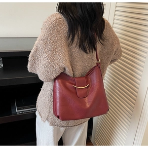 Detail view of the vintage wine red leather tote with a gold crescent metal buckle