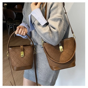Detail view of brown quilted bucket bags in two sizes with gold turn-lock closures