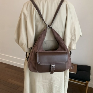 Detail of retro patchwork backpack featuring brown suede leather and contrast white stitching