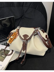 Borsa a tracolla in tela e pelle marrone con design a pieghe e dettagli di nappe