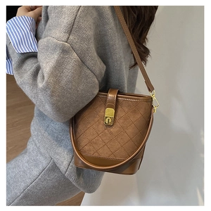 Brown quilted bucket bag with gold clasp shown on model for size and style reference