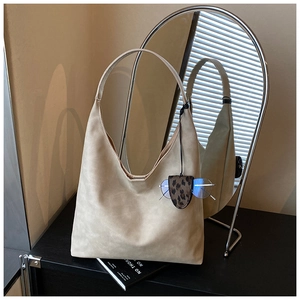 Detail of beige hobo bag with a leopard print glasses holder and silver metal frames