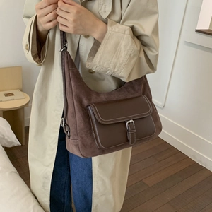 Detail of vintage brown suede shoulder bag with contrast stitching and silver hardware