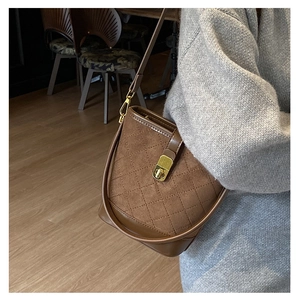 Detail of vintage brown quilted bucket bag with gold twist lock and adjustable strap